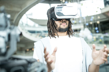 Young developer with virtual reality headset at robotic workshop