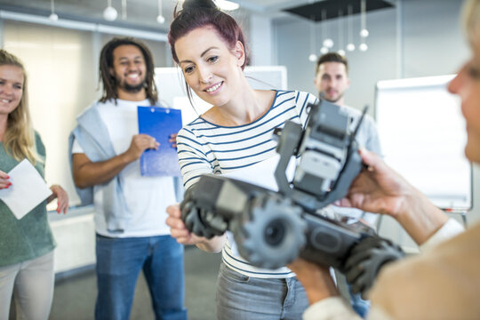 Technician with colleagues examining combat car at workshop