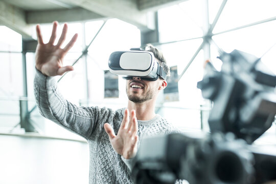 Developer with virtual reality headset gesturing at workshop