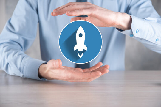 Startup business concept, Businessman holding in hand icon rocket is launching and soar flying out from screen with network connection on dark.flat icons with long shadows.Profit, rise, development.