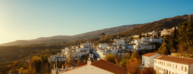 Sunset in the village of Valor in the Alpujarra of Granada with the bell tower of the church in the center of the photo