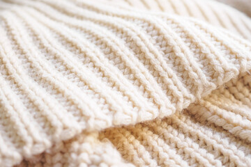 closeup beige knitted woolen fabric texture background