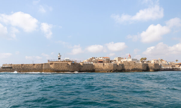 View from the boat to the Mediterranean Sea, the fortress wall and buildings in the old city of Acre in northern Israel