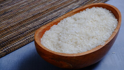 Rice in an oval wooden bowl and some kitchen ornaments neatly and beautifully arranged on a table. food and beverage concept. 