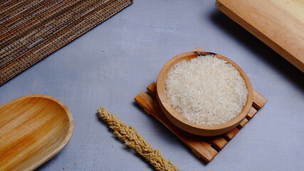 Rice in an oval wooden bowl and some kitchen ornaments neatly and beautifully arranged on a table. food and beverage concept. 