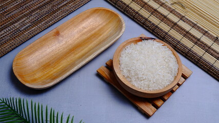 Rice in an oval wooden bowl and some kitchen ornaments neatly and beautifully arranged on a table. food and beverage concept. 