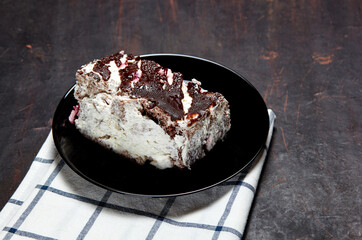 Plate with slice of tasty chocolate cake on table. Yummy dessert on on wooden background, closeup