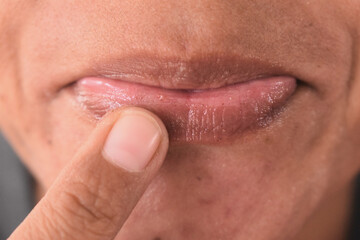 Asian woman applying lip balm closeup