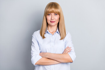 Photo of serious charming lady dressed white shirt arms crossed smiling isolated grey color background