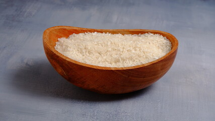 Rice in an oval wooden bowl and some kitchen ornaments neatly and beautifully arranged on a table. food and beverage concept. 