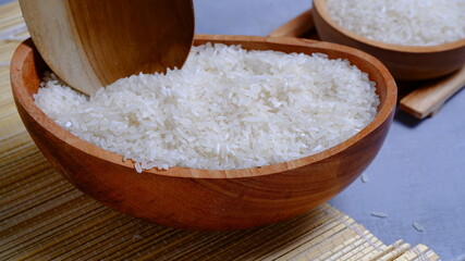 Rice in an oval wooden bowl and some kitchen ornaments neatly and beautifully arranged on a table. food and beverage concept. 