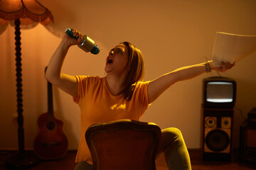 Woman playing music and singing on a wireless microphone in a retro vintage room.