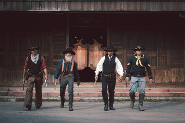 Vintage style cowboys group wearing cowboy shirts and trousers everybody showing gun in hand ,like...