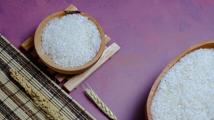 Rice in an oval wooden bowl and some kitchen ornaments neatly and beautifully arranged on a table. food and beverage concept. 