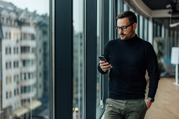 Serious adult man, checking his message on his company phone.