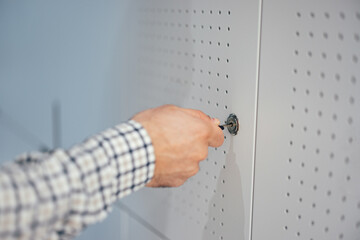 Closeup picture of a key being put into the lock of an office locker.