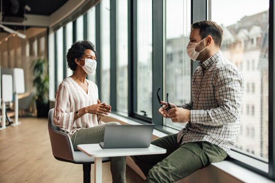 Two Diverse Colleagues With Masks, Exchanging Interesting Ideas.