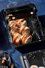 Unagi roll with eel packed in plastic takeaway tray for delivery to client