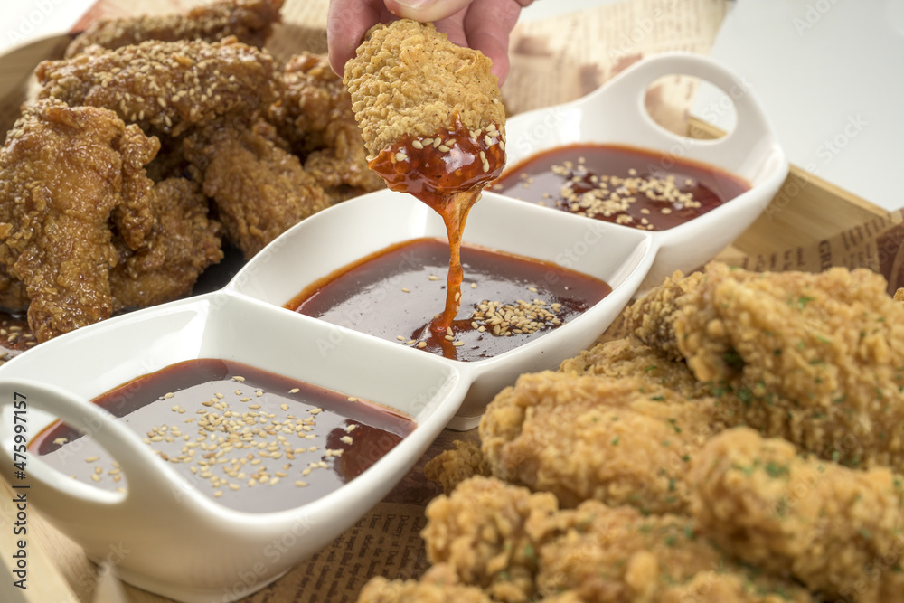 Poster closeup shot of korean fried chicken with dipping sauce isolated on a white background