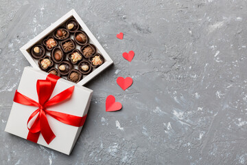 Delicious chocolate pralines in red box for Valentine's Day. Heart shaped box of chocolates top view with copy space