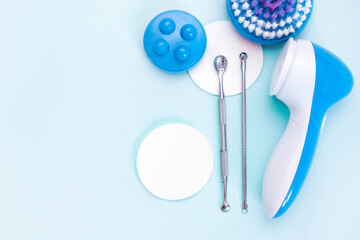 uno scoop and facial massager are on a soft blue background. flat lay, cosmetology