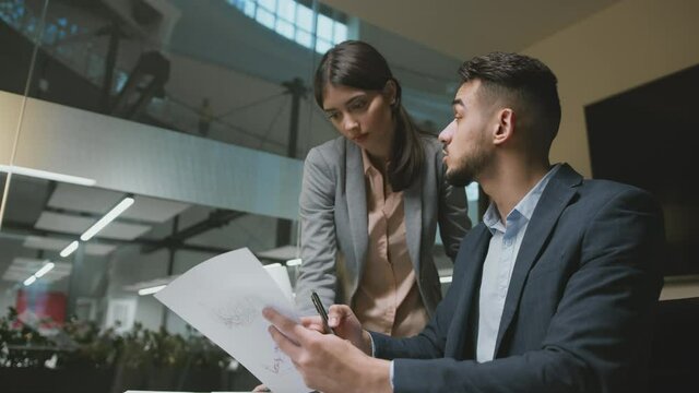Probationary period at work. Young middle eastern man team leader explaining project details to woman newcomer