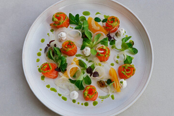 salmon gravlax, salt and sugar cured fresh salmon in a serving plate with leaves and garnish, fine dining