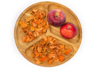 Dried sliced and fresh apples on wooden dish, top view
