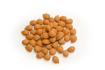 Heap of shelled apricot kernels on a white background