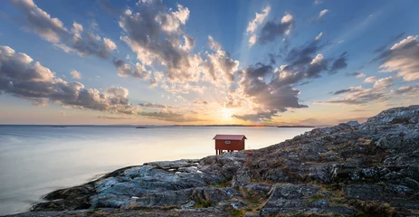 Foto op Canvas a colorful sunset of a red little fisherman's hut at the coast of sweden. Longe exposure © Johannes