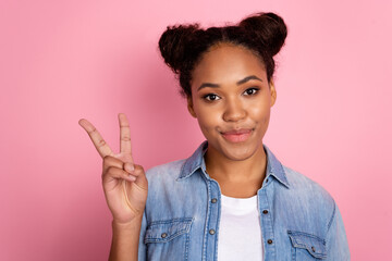 Photo of youth african girl good mood show fingers peace cool v-symbol isolated over pink color background