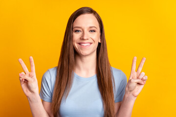 Photo of young attractive girl sho fingers peace cool v-symbol hi greetings isolated over yellow color background