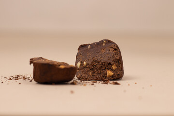 Chocolate truffle halved in two pieces on a beige background