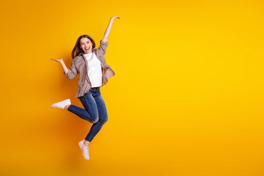Full size profile side photo of young cheerful girl jump advertise advantage solution isolated over yellow color background