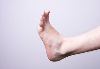 isolated male leg on gray background