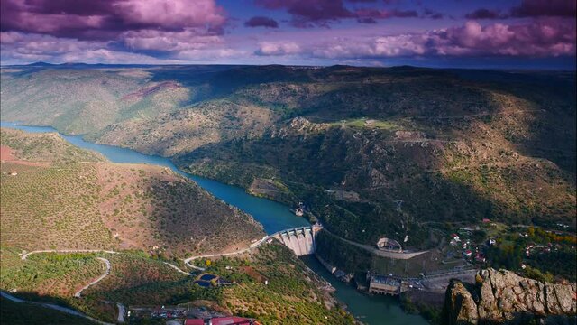 Time lapse of clouds moving over mountain and Douro river with spanish Saucelle Dam. Border between Portugal and Spain. National Parks. View from portuguese Penedo Durao lookout.