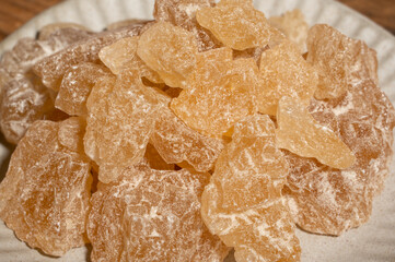 The rock sugar in the container is on the wood grain table