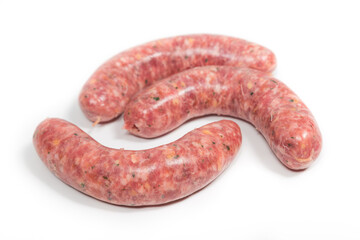 Three crude sausages with mushrooms on a white background