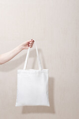 Mockup of a white tote reusable eco cotton shopper bag on a white background. Sustainability, environmentally friendly.