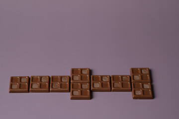 Playing domino with small square milk chocolate.
