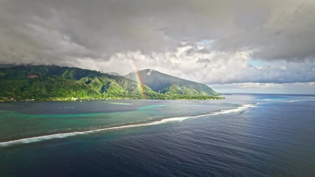 Aerial view of beautiful tropical island, rainbow, blue ocean and coral reefs. Paradise island of Tahiti in French Polynesia. 
