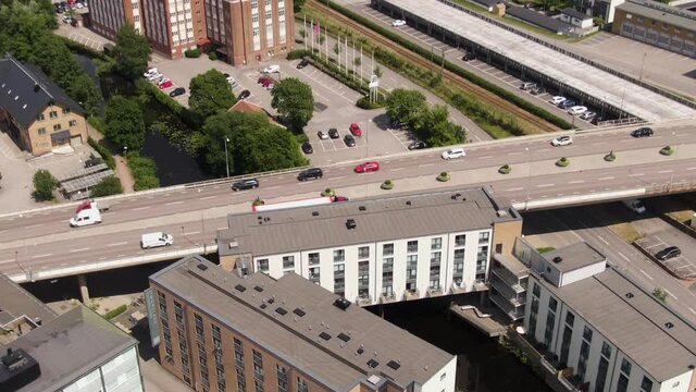 Industrial chimney and street traffic of Swedish town, aerial drone view