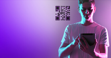 QR code in portable tablet. Technological image on purple neon background. Tablet in hand of man....