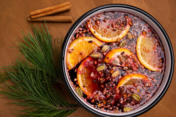 mulled wine in a cup with orange slices and spices on a wooden surface