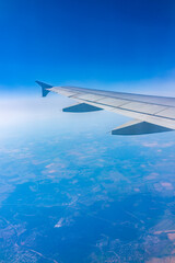 Obraz premium View from the airplane window at a beautiful blue clear sky and the airplane wing