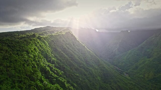 Epic aerial reveal shot of tropical volcanic island with beautiful sunlight. Paradise jungle valley in Tahiti, French Polynesia. 