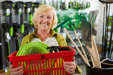Glückliche Kundin mit Einkaufskorb im Baumarkt