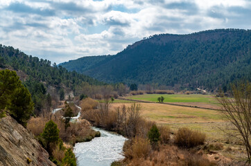Fototapeta na wymiar Río Cabriel rodeado de montes y tierras de siembra a la altura de la aldea 
