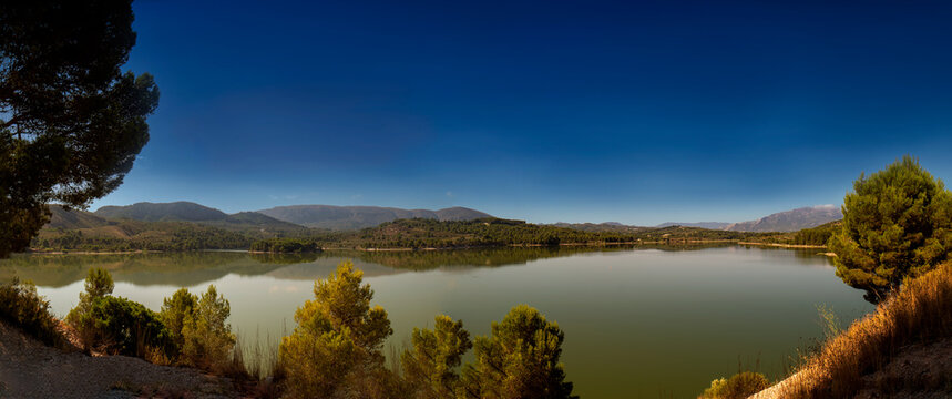 Pantano de Beniarrés, rodeado de bosques y montes, aprovechando el cauce del río Serpis.