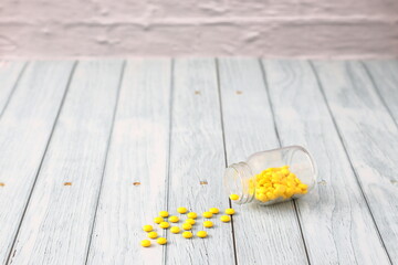 薬｜黄色の錠剤と倒れた瓶